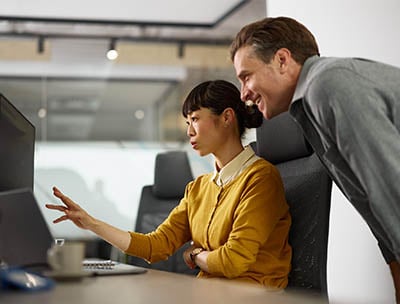 Colleagues reviewing data on a screen.