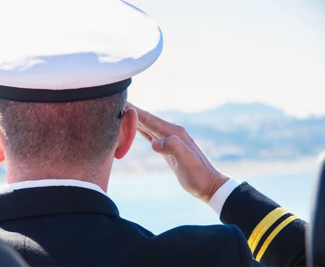 The back of a military member saluting.