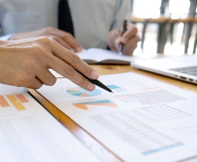 Two people's hands near several charts. 