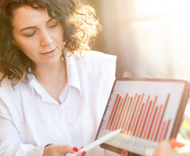 A woman reviewing financials on a tablet.