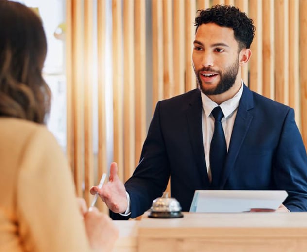 Two people talking by a desk.