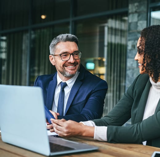 Two professionals sitting at a desk.