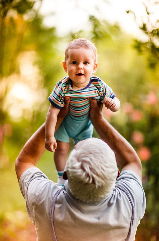 A grandfather holding a baby.