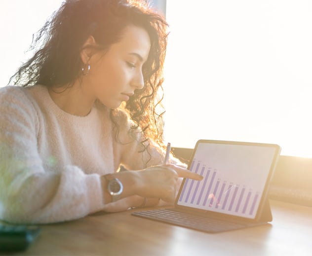 A woman showing a graph on her tablet.
