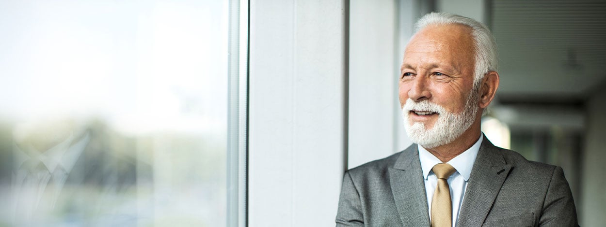 An older corporate executive smiling.