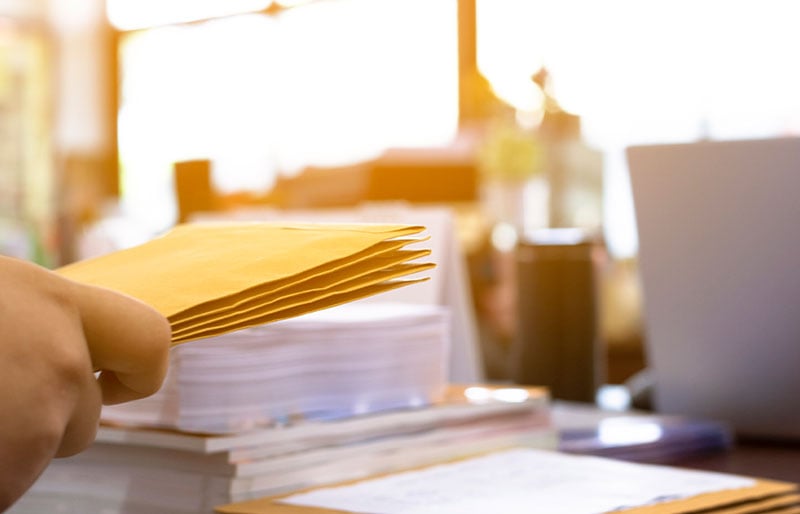 A desk with papers and envelopes.