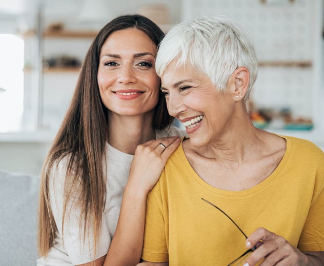 Two generations of women smiling.